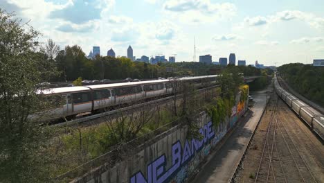 Ascending-drone-shot-of-train-and-cars-on-suburb-area-of-Atlanta-City-during-sunny-day