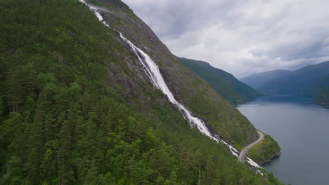 Side-aerial-view-of-impressive-Langfoss-falls-cascading-down-rocky-mountainside
