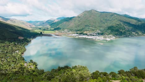 Aerial-view-of-small-town-of-Havelock-nestled-by-the-waters-edge-at-head-of-Pelorus-Sound-in-Marlborough-Sounds,-with-calm,-sheltered-bay-in-the-South-Island-of-New-Zealand-Aotearoa
