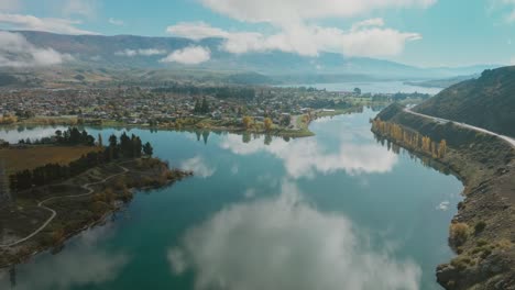 Aerial-view-across-scenic,-calm-and-placid-Lake-Dunstan-towards-Cromwell-town-in-Central-Otago-region-of-South-Island,-New-Zealand-Aotearoa