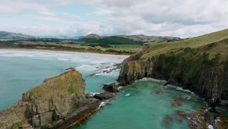 Aerial-view-of-coastal-rock-erosion-on-the-wild,-rugged-and-rocky-shoreline-of-Cannibal-Bay-in-Catlins,-South-Island-of-New-Zealand-Aotearoa