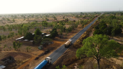 Luftaufnahmevideo-Von-Lastwagen,-Die-In-Burkina-Faso,-Afrika,-Abseits-Der-Straße-Fahren