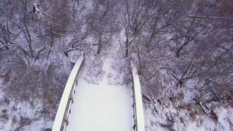 Aerial-rises-over-long-abandoned-highway-bridge-over-winter-river