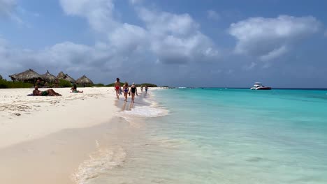 People-enjoying-white-sand-beach-and-crystal-clear-transparent-turquoise-water-in-Klein-Curaçao,-dream-vacation-destination-in-Little-Curaçao-the-tropical-Dutch-Caribbean-island,-4K-static-shot