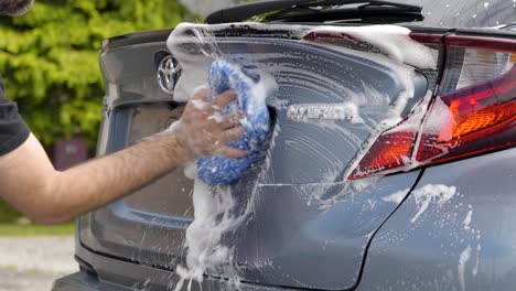 Washing-rear-trunk-on-blue-silver-car