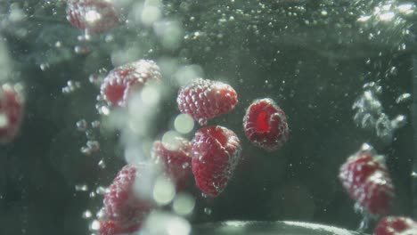 Red-Raspberries-Drop-Into-A-Container-Of-Bubbling-Water