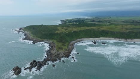 Expansive-aerial-view-of-rugged,-rocky-and-wild-coastal-landscape-and-Tasman-Sea-at-Cape-Foulwind-on-West-Coast,-South-Island-of-New-Zealand-Aotearoa