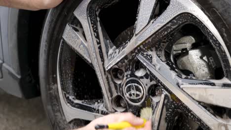 Cleaning-car-wheel-with-detailing-brush