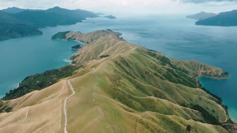 Stunning-aerial-viewpoint-of-the-narrow-crossing-between-the-mainland-of-Te-Aumiti-French-Pass-and-D'Urville-Island-in-Marlborough-Sounds,-South-Island-of-New-Zealand-Aotearoa