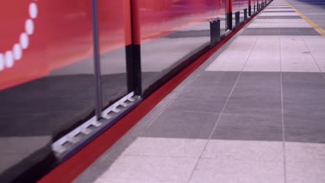 Low-angle:-Clean-red-subway-train-doors-close-and-train-leaves-station