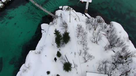 Vista-De-Drones-En-La-Zona-De-Tromso-En-Invierno-Que-Muestra-Un-Mar-Turquesa-Cristalino-Que-Rodea-Una-Isla-En-La-Vista-Superior-De-Noruega
