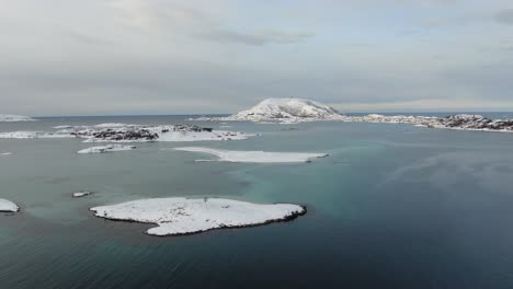 Vista-De-Drones-En-La-Zona-De-Tromso-En-Invierno-Volando-Sobre-Islas-Nevadas-Rodeadas-Por-El-Mar-En-Noruega