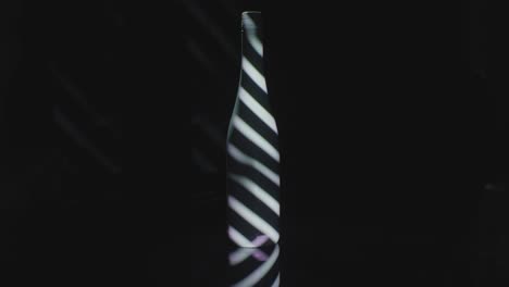 Bars-of-light-projected-on-a-dark-wine-bottle