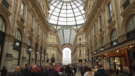 Los-Turistas-Caminan-Por-La-Galería-Vittorio-Emanuele-II-Con-Las-Tiendas-Prada-Y-Louis-Vuitton-Al-Fondo.