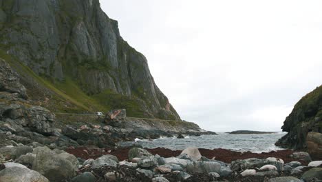 Norwegian-coastal-shore,-with-a-car-driving-in-the-distance