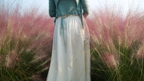 Fit-Woman-in-Dress-Walking-Through-Blooming-Pink-Muhly-Grass-at-Herb-Island-Farm---Static-Low-Angle-Slow-Motion