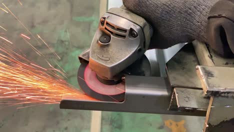 Hands-using-a-grinding-machine-to-grind-iron