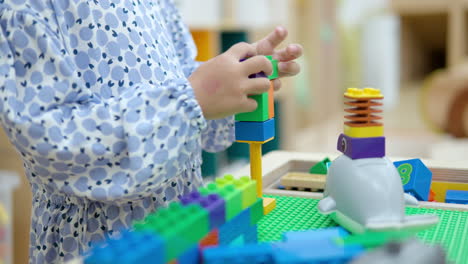 Kleines-Mädchen-Spielt-Mit-Bunten-Legosteinen-Im-Indoor-Spielzimmer