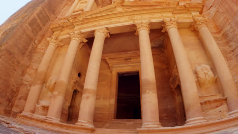 Low-angle-panning-shot-of-the-ancient-ruins-of-The-treasury-in-Petra
