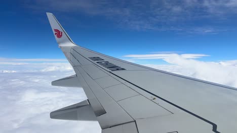 Air-China-Airplane-Wing-Flying-Above-Clouds