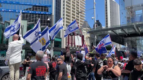 Pro-Israel-demonstrators-hold-Israeli-flags-in-support-of-Israel,-slow-mo