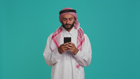 Islamic-man-works-on-his-mobile-gadget