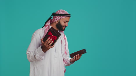 Muslimischer-Erwachsener-öffnet-Geschenkbox-Mit-Schleife