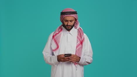 Hombre-Musulmán-Navegando-Por-La-Aplicación-Para-Teléfonos-Inteligentes
