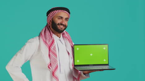 Persona-Islámica-Muestra-Una-Computadora-Portátil-Con-Pantalla-Verde