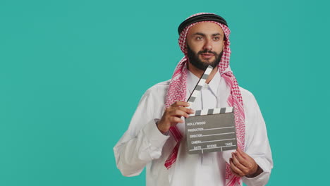 Middle-eastern-man-holds-clapperboard
