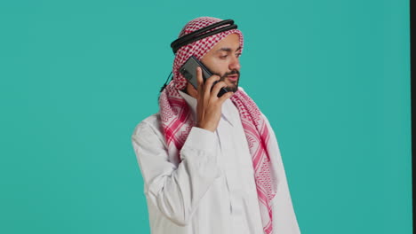 Hombre-Musulmán-En-Traje-Tradicional-Enviando-Mensajes-De-Texto