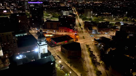 Aerial-view-around-the-illuminated-St-John-church-and-streets-of-River-West,-night-in-Chicago