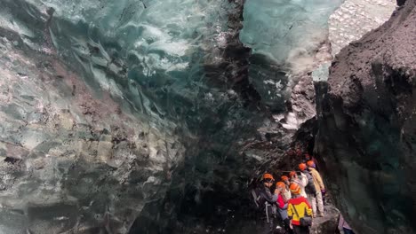 Guided-tourist-group-visiting-breathtaking-blue-ice-cave-in-Iceland