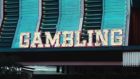 Neon-lights-sparkle-in-gold,-pink,-and-blue-to-light-up-a-gambling-sign-in-the-Fremont-old-town-district-of-Las-Vegas