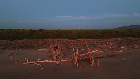 Holztipi-An-Der-Strandküste-Bei-Sonnenuntergang-Mit-Dem-Mond