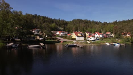 Rise-Drone-Shot-of-a-little-Village-nearby-a-lake-in-Sweden