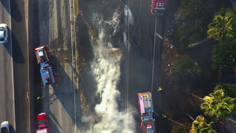 Aerial-top-down-shot-above-firefighters-at-a-urban-fire-scene-in-California,-USA
