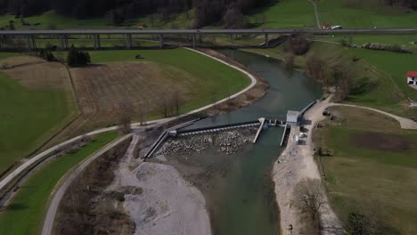 A-pull-away-drone-shot-of-a-hydropower-plant-in-the-blue-land,-germany