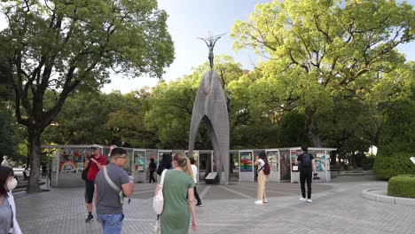 Turistas-Que-Visitan-El-Monumento-A-La-Paz-De-Los-Niños-En-Hiroshima-En-Una-Tarde-Soleada