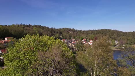 Reveal-Drone-Shot-of-a-little-Village-nearby-a-lake-in-Sweden