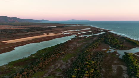 Aerial-drone-footage-of-beach-seaside-coast-and-lagoon-swamp-at-sunset
