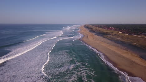 Cinematic-aerial-drone-stunning-Quik-Pro-coastline-morning-huge-glassy-waves-swell-barrels-Hossegor-Seignosse-France-Biarritz-Basque-Country-pan-downward-jib-movement