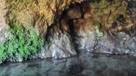 Kristallklares-Wasser-Strömt-In-Kaskaden-Aus-Den-Felsen-Und-Bildet-Eine-Ruhige-Innere-Wasserquelle,-Ein-Faszinierendes-Zeugnis-Der-Schönheit-Und-Ruhe-Der-Natur