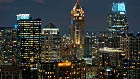 Atlanta-Georgia-Aerial-v899-hyperlapse-zoomed-shot,-flyover-Piedmont-Park-capturing-illuminated-Midtown-cityscape,-light-up-high-rise-buildings-at-dusk-night---Shot-with-Mavic-3-Pro-Cine---July-2023