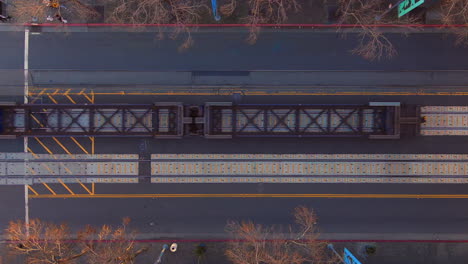 Static-topdown-aerial-of-pedestrians-waiting-for-passing-cargo-train