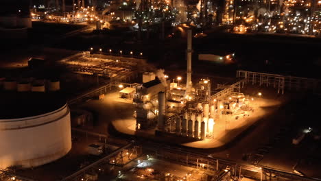 Aerial-view-of-oil-refinery-process-plant-at-night,-establishing-view