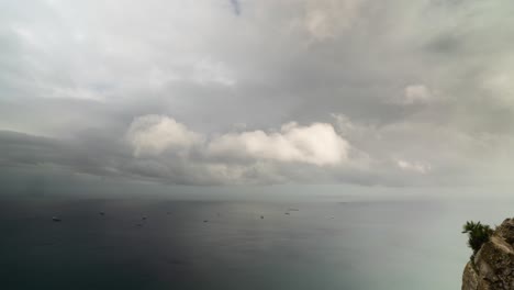 Dark-stormy-clouds-flowing-above-many-anchored-cargo-vessels,-time-lapse