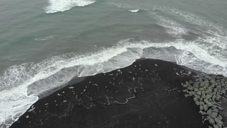 Aerial-of-diamond-beach-in-Iceland,-with-black-sand-and-ice-blocks