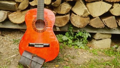 Ledertagebuch-Und-Rote-Akustikgitarre,-Künstlerische-Rustikale-Holzstapelszene