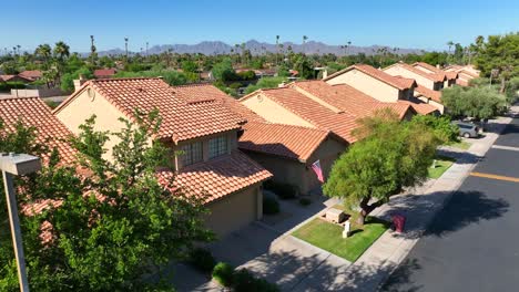 Southwest-USA-neighborhood-Aerial-view-of-terracotta-roof-homes,-green-trees,-with-mountains-in-the-background